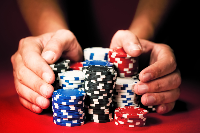 Mans-hands-move-the-winnings-casino-chips-on-red-table.jpg